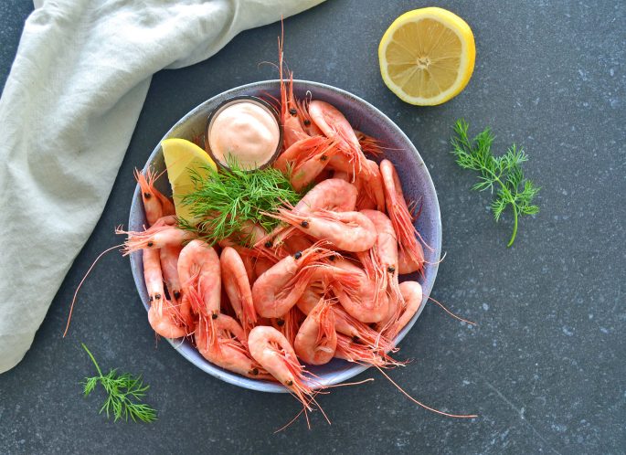 Opskrift pil-selv rejer med cocktailsauce anrettet i en skål med citron og frisk dild