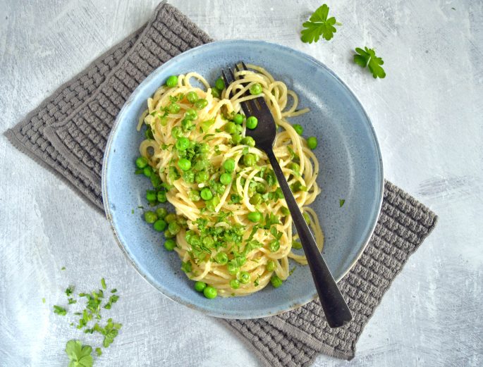 Opskrift på cremet pasta med grøntsager, anrettet i en skål med frisk persille på toppen